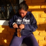 Marisol crocheting her shoe to repair it. The dog ate the original sandal, so she crocheted brand new straps.