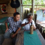 A craftsman making a wine bottle cover out of rattan, a grass.